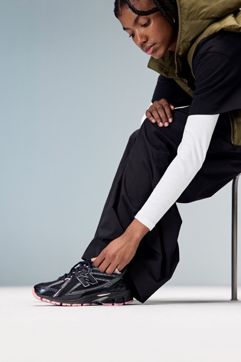 Woman sitting down and wearing new balance 1906 sneakers